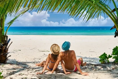Romantic couple relaxing on tropical beach under palm trees