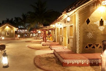 Traditional Rajasthani village huts illuminated at night in Chokhi Dhani Jaipur Rajasthan cultural theme resort