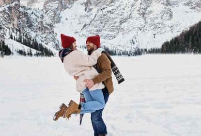 Romantic couple enjoying snowy mountain landscape in winter