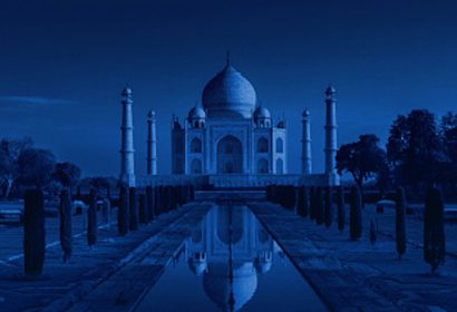 Taj Mahal at night under full moon with reflection in water
